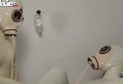 Two latex lesbians touch each others pussies and masturbate on a gynochair