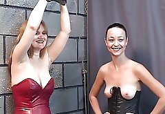 Bound BDSM slut watches Brunette with ponytail eat fruit topless with master