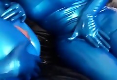 Kinky girl in latex fingers pussy trough the slit