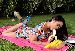 Kinky Asian black head uses a banana to polish her wet pussy outdoors