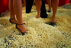 Wild group sex orgy on the stage covered with pop corn